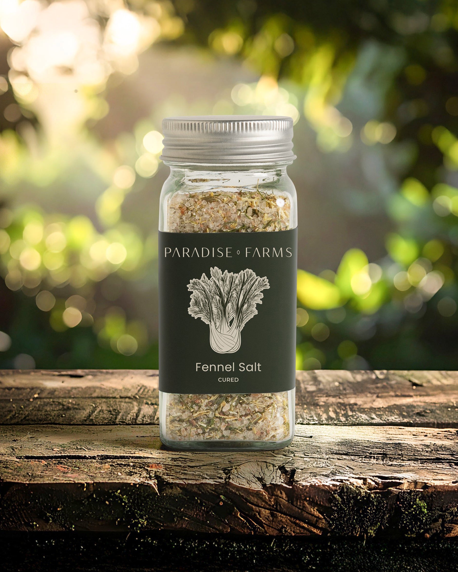 Jar of Paradise Farms Fennel Salt on a wooden surface with a blurred natural background
